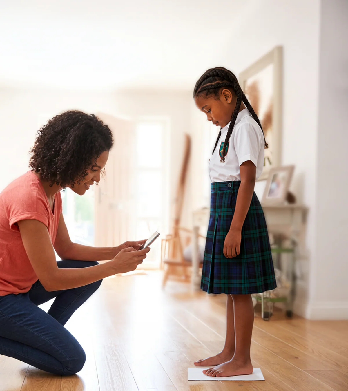 A parent measuring a child's feet using a mobile phone
